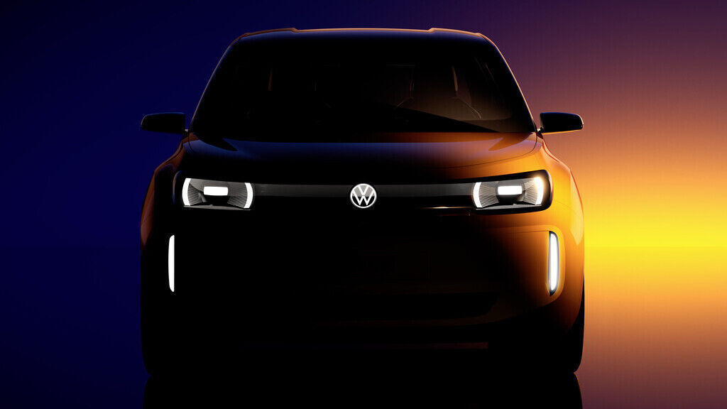 A stylized front view of a Volkswagen vehicle, presented in a dark setting with illuminated lighting elements. The headlights and vertical light strips are turned on, while the background features a gradient from deep blue to warm orange.